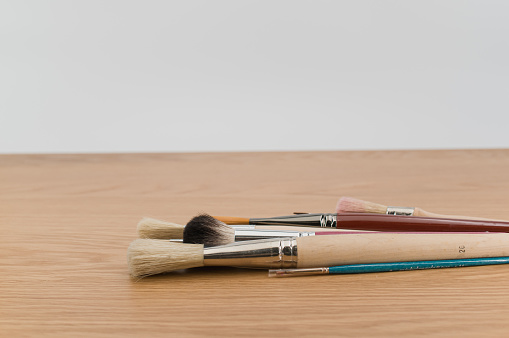 set of paintbrushes on a wooden tabletop with copy space