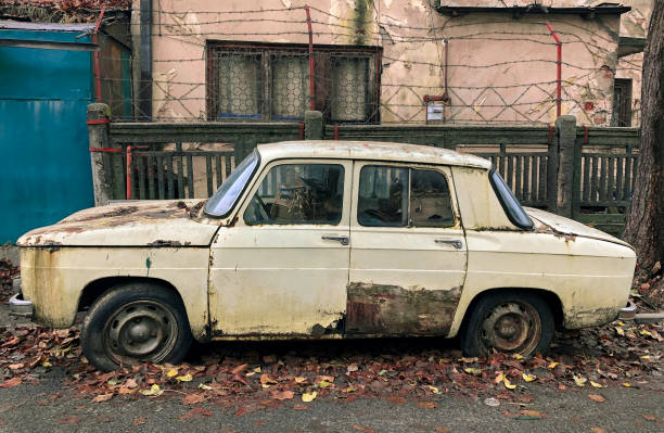istock Old abandoned auto car in front of a weathered house 1454543416