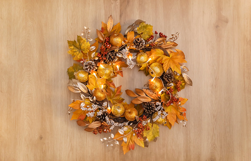 Dried floral wreath with led light on wooden background. Autumn home decor. Thanksgiving Concept