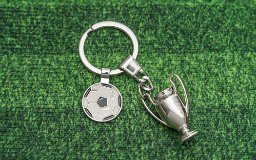 Keychain with a soccer ball shape on green background