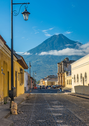 Antigua Guatemala, Guatemala – February 15, 2015: An Antigua Guatemala street with its colonial-style buildings and Agua Volcano in the far, Guatemala