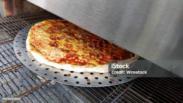 Closeup Of Pizza With Cheese And Salami In The Commercial Oven Stock Photo - Download Image Now