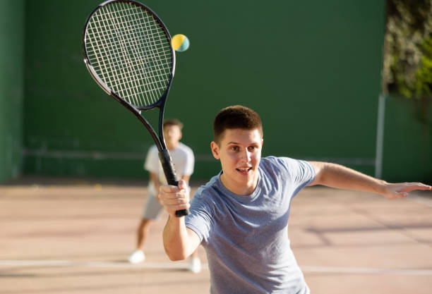 istock Young man playing frontenis at open-air fronton court in summer 1454547406