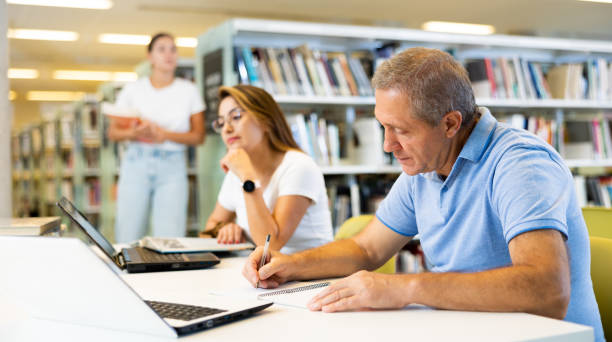 istock View on a mature man and a young latina student studying together 1454547467
