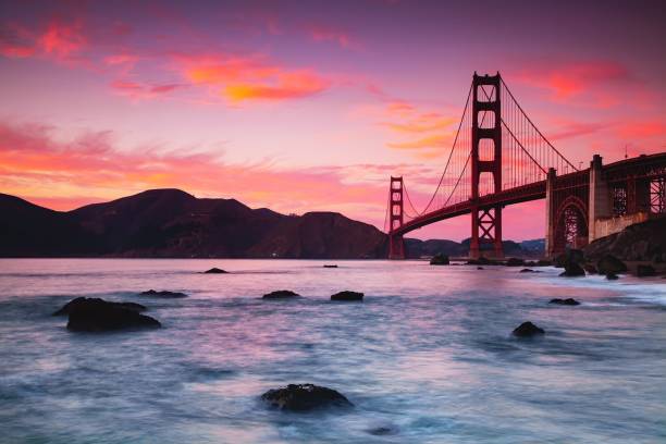 紫色の夕暮れ時に水を渡るゴールデンゲートブリッジの美しい景色、サンフランシスコ、アメリカ - san francisco county golden gate bridge skyline night ストックフォトと画像