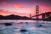 Beautiful view of the Golden Gate Bridge across the water at purple sunset, San Francisco, USA