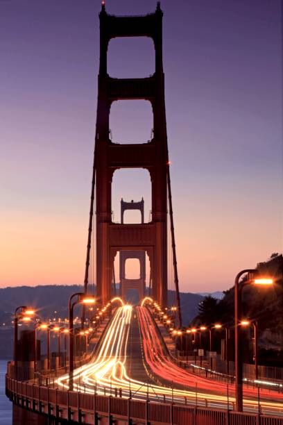 prise de vue verticale à longue exposition du pont golden gate avec des lumières au coucher du soleil - san francisco bay area golden gate bridge night bridge photos et images de collection