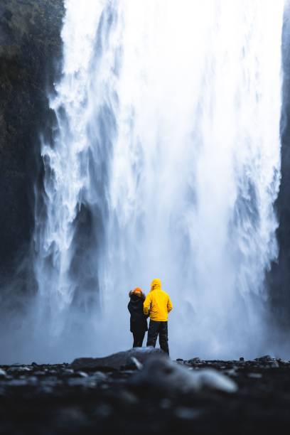 istock Couple standing in front of a waterfall 1454552819