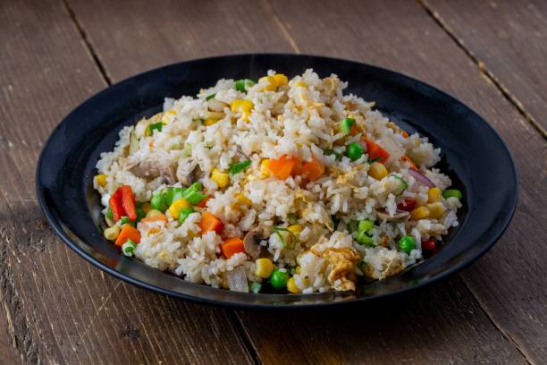 istock Fried rice with vegetables toppings on a black plate 1454553134