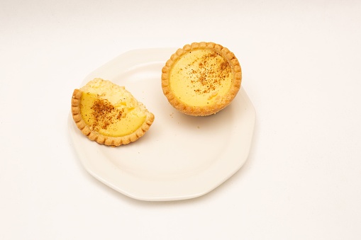 Two home made Egg Custard Tart on china plate isolated on white