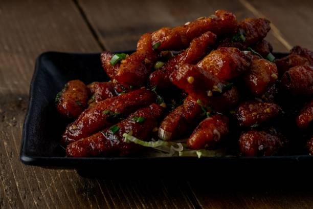 istock Freshly cooked chicken wings and sausage on a black plate 1454559244