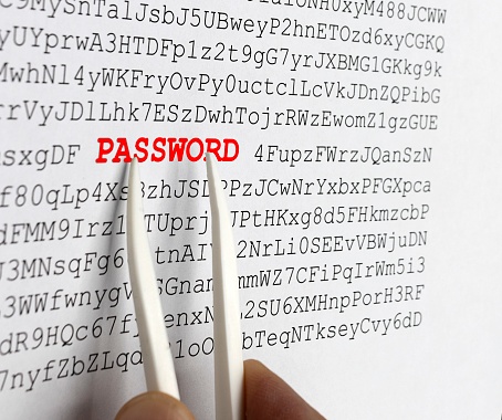 With a tweezers, the word password is pointed out in red in a set of random letters, cybersecurity concept
