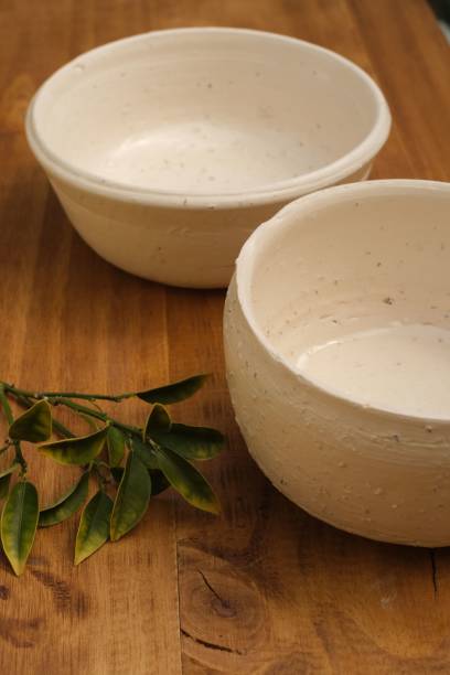istock White empty ceramic bowls and green leaves on a wooden table 1454560402