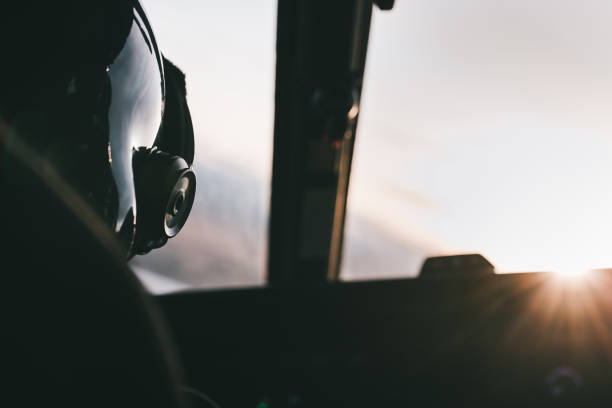 istock Helicopter pilot and helmet with sunset ahead in the cabin 1454561259