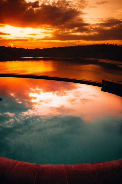 istock Vertical shot of a pool reflecting the sunset sky 1454561314
