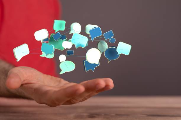 istock Closeup of speech bubbles signs hovering over a male hand - communication concept 1454561765