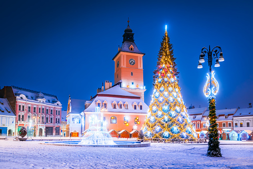 Brasov, Romania. Snowy night with Christmas Market and Tree winter season decorations in historical Transylvania.
