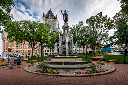 Québec City, Canada - August 21, 2022: View of Place d'Armes with Fountain Monument of Faith (1915)  an Chateau Frontenac Hotel in background.