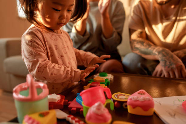 istock Focused asian girl play with toy figures at table 1454563280