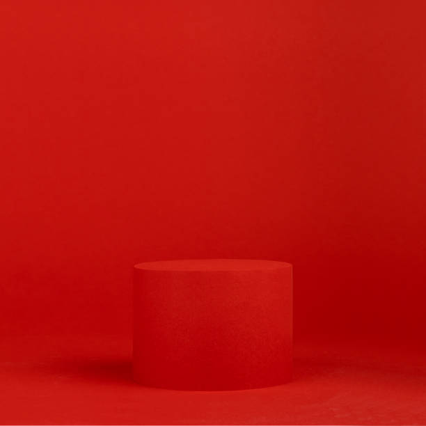 istock Luxury bright red scene - single cylinder podium mockup on table for presentation cosmetic products, gifts, goods in fashion trendy modern style, copy space, square. Template for advertising, design. 1454563287