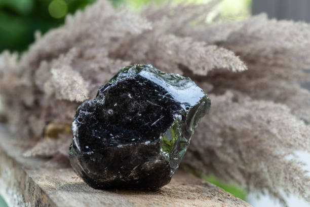 Black Obsidian Mineral Rock Sample over Wood