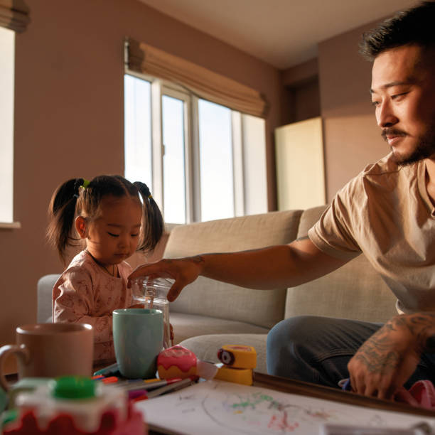 istock Father on sofa take glass jar from daughter hands 1454565010