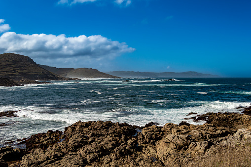 The rocky coast of Laxe in Galicia with a mountain with a lot of wind and hellos