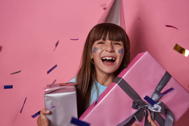 istock Joyful girl with gift boxes in flying confetti 1454569299