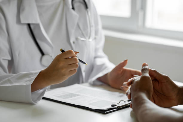 istock Female doctor filling up an application form while consulting patient 1454570652