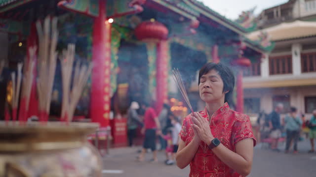 Asian mature woman praying on Chinese new year.