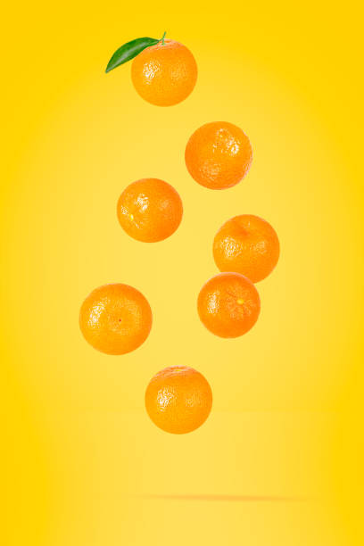 istock Isolated clementine on the air on yellow 1454571618