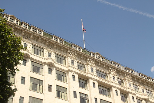 Paris, France – May 25, 2014: A low-angle shot of the Savoy building in London with a flag placed on the roof