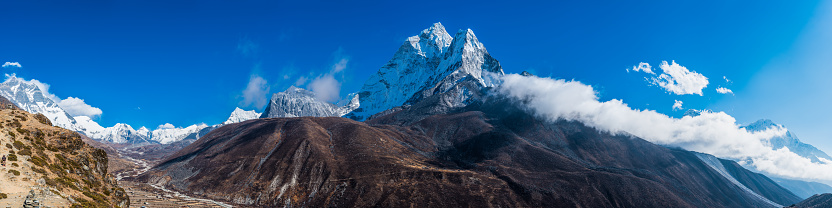 Ama Dablam’s jagged peaks soaring over the Sherpa farms in Dingboche overlooked by Lhotse, Island Peak and Baruntse high in the Himalayan mountains of Nepal.