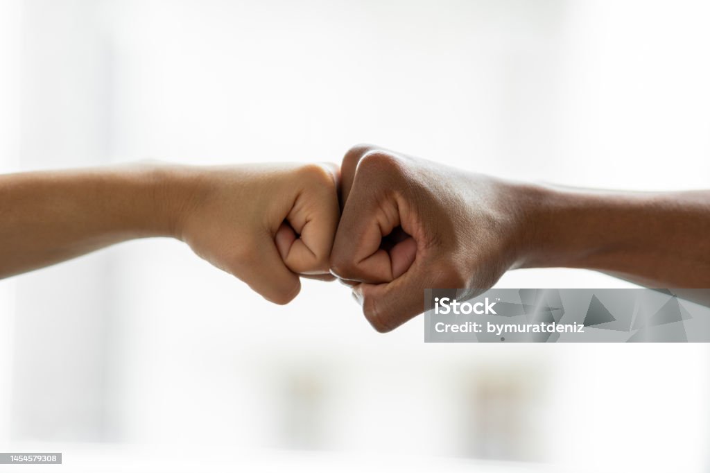 Hands giving a fist bump in agreement partnership Reconciliation Stock Photo