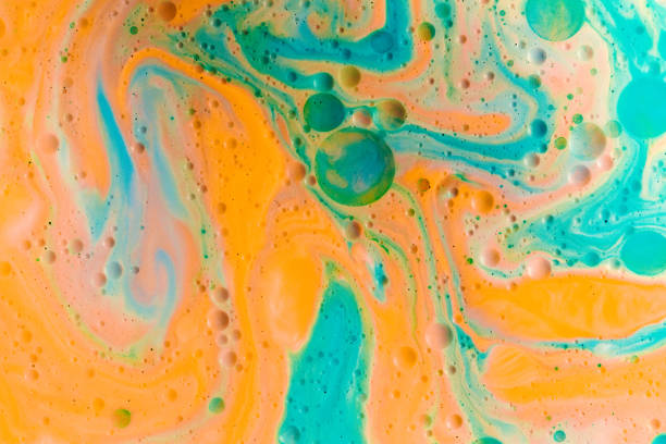 istock Abstract shapes in orange and blue paint mixed with oil 1454579596