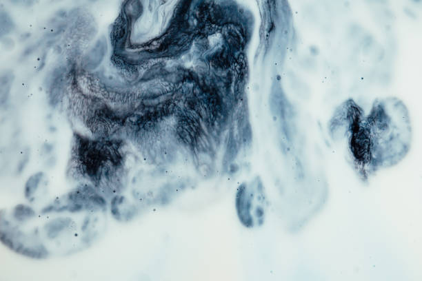 Macro close up depicting the abstract forms and shapes in a mixture of blue and orange paint and oil.