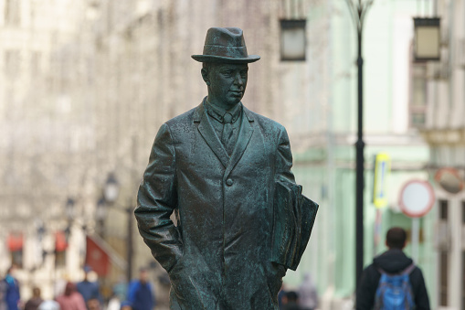Moscow, Russia - March 30, 2021: Photography of a bronze statue of russian composer Sergei Prokofiev in hat in Moscow. Kamergersky Lane. Musical heritage theme.