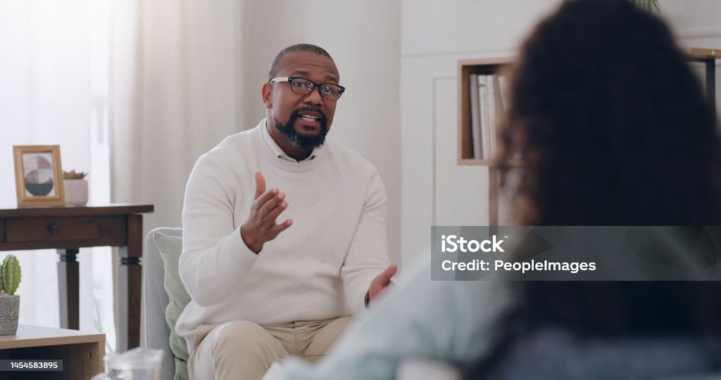 Therapy, support and psychologist talking to a woman about mental health, depression and anxiety. Psychology, healthcare and African therapist with advice for a patient while counseling in an office Psychotherapy Stock Photo