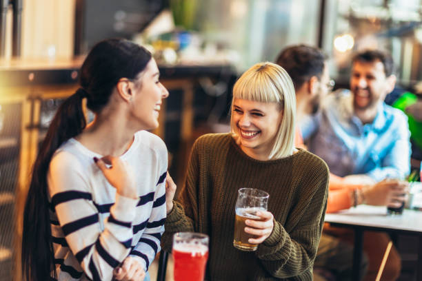 istock Smiling young friends drinking craft beer in pub 1454585118