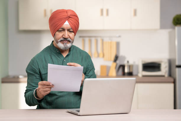 istock Indian sikh man using laptop at home, stock photo 1454585585
