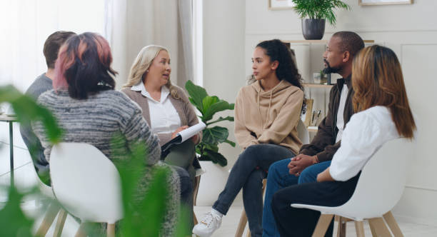 Diversity, mental health and group therapy counseling support meeting, healthy conversation and wellness. Psychology counselor, psychologist help people and talk about anxiety, depression or stress stock photo