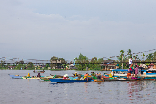 Banjarmasin, Kalimantan - Indonesia – 04 November 2022: everyday in the morning, women in floating market lok baintan, Banjarmasin city, Indonesia paddled their boat to carry out buying and selling various basic needs such as vegetables and crops from villages along martapura river.