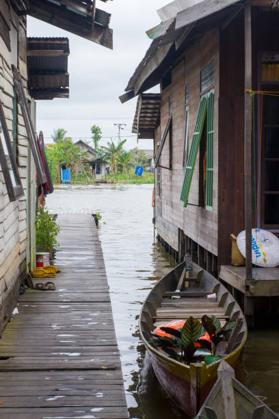 Banjarmasin, Kalimantan - Indonesia – 04 November 2022: houses and boats by the martapura river in Banjarmasin, South Kalimantan, Indonesia.