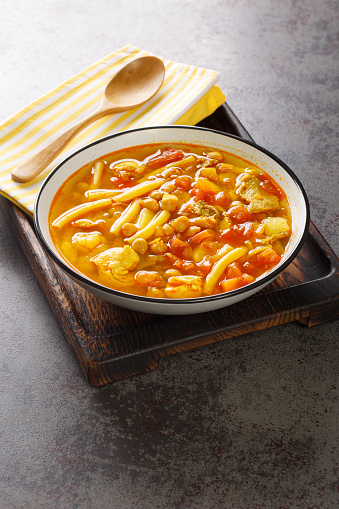 Rancho Canario is a traditional Canarian soup, with a stew-like consistency from the Canary Islands closeup on the plate on the table. Vertical