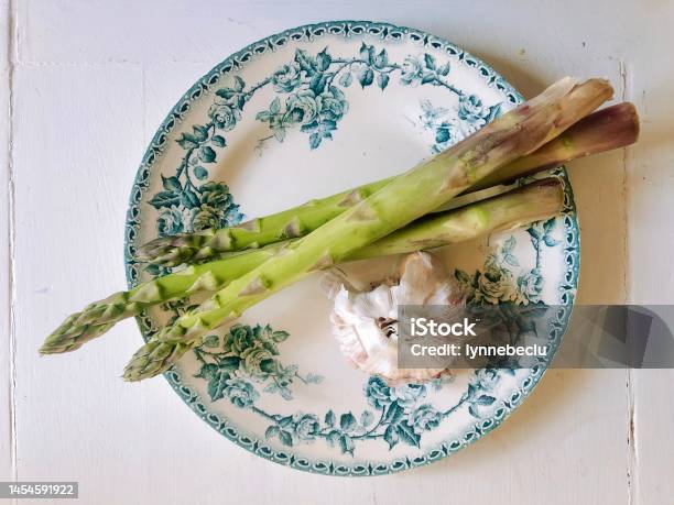 Asparagus And Garlic Bulb On Antique French Porcelain Plate Stock Photo - Download Image Now