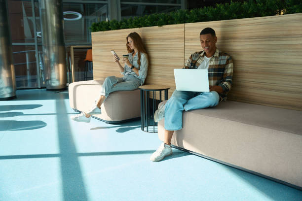 istock Two colleague sitting and working in office lobby 1454593391