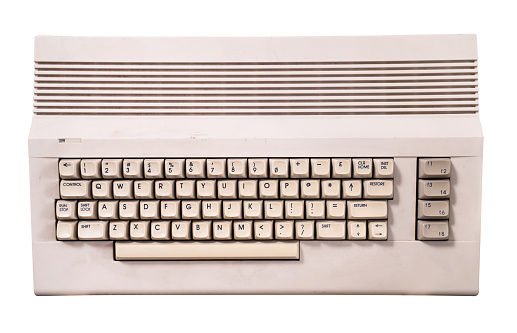 top view closeup of vintage cream colored home computer keyboard isolated on white