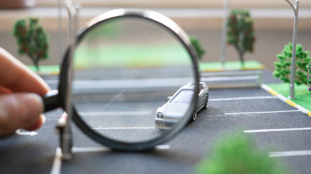 istock Looking through a magnifying glass at a car model 1454596780