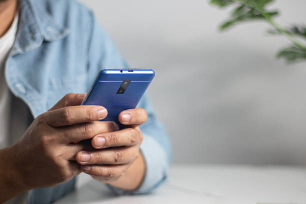 istock Men's hands on the table use mobile phones, technology, communications, the Internet. 1454607417