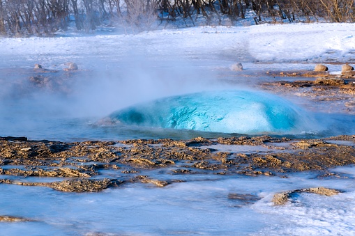 A closeup shot of a natural stream of geysir and its steam in the territory of Iceland